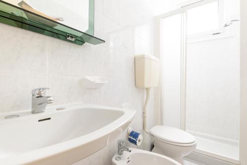 biała łazienka z umywalką i toaletą w obiekcie Hotel Verde Luna w mieście Cervia