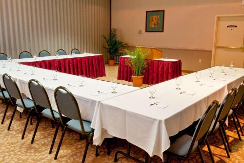 a long table in a room with red tables and chairs at Comfort Suites University Area Notre Dame-South Bend in South Bend