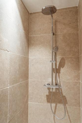 une douche avec pommeau de douche dans une salle de bain dans l'établissement les palivettes12, à Malaucène
