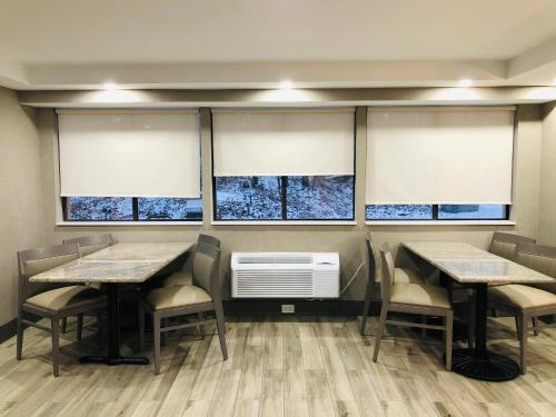 a dining room with tables and chairs and windows at Best Western West Lebanon-Hanover in West Lebanon