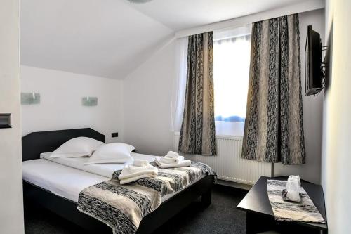 a hotel room with a bed and a window at Casa Mara in Ocna Şugatag