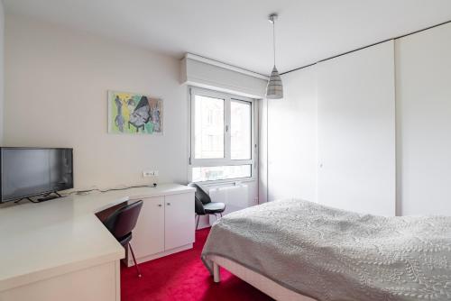 une chambre avec un lit, un bureau et une télévision dans l'établissement CityCosy-Strasbourg - Chic Oberlin Contades, à Strasbourg