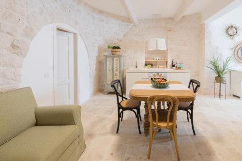 a kitchen and dining room with a table and chairs at Trulli Resort Aia Piccola in Alberobello