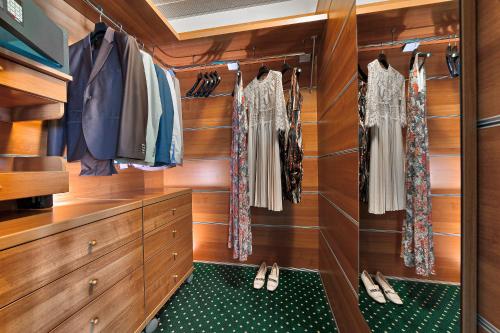 a walk in closet with wooden cabinets and shoes at Hotel Terme Antoniano in Montegrotto Terme