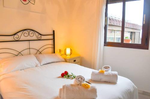 una camera da letto con un letto bianco e asciugamani di Ático céntrico plaza Moravia ,San Julian. a Siviglia
