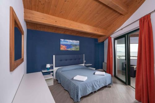 a bedroom with blue walls and a bed in a room at La Rotonda Trilocale vista mare in Albinia