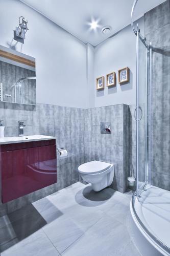 a bathroom with a toilet and a sink and a shower at Kamienica Morska Gdynia in Gdynia