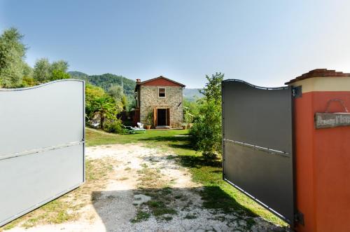 an open gate in a yard with a house at Podere L'Istrice in Massa e Cozzile