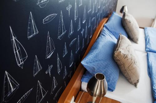 a bedroom with a bed with blue pillows and a chalkboard at Hotel Hus Achtern Diek in Insel Neuwerk