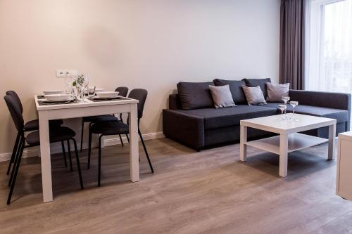 een woonkamer met een bank en een tafel bij AM Apartamentai in Klaipėda