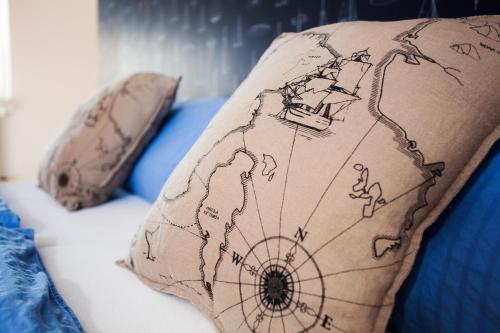 a pillow with a map on it on a bed at Hotel Hus Achtern Diek in Insel Neuwerk