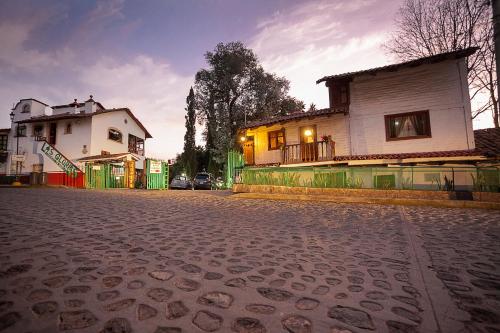 an empty street with a house and a building at Htl & Villas Las Glorias Mazamitla, céntricas, parking, jardín in Mazamitla