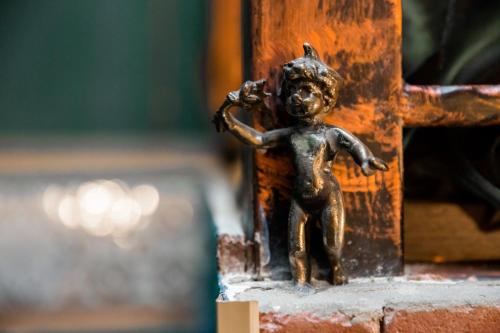 a small bronze figurine of a child standing on a door at Tiflis Inn Boutique Hotel in Tbilisi City