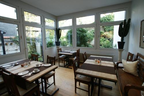 a dining room with tables and chairs and windows at Hotel Stern in Düsseldorf
