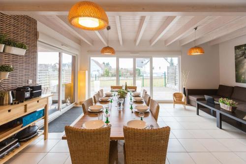 a dining room with a long table and chairs at LES MAISONS SOLAIRES Contact O6614O9II9 Villa pour 15 pers maxi in Griesheim-près-Molsheim