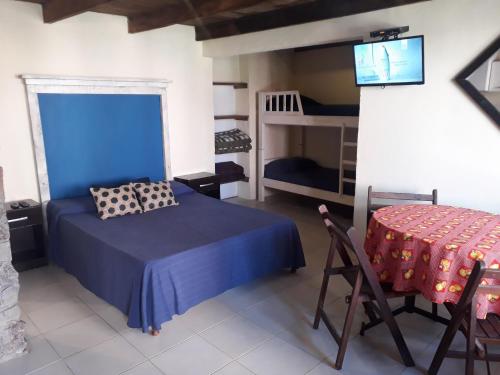 1 dormitorio con 1 cama, TV y mesa en Belarmina posada del mar., en Aguas Dulces