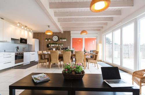 een keuken en een woonkamer met een tafel en een laptop bij LES MAISONS SOLAIRES Contact O6614O9II9 Villa pour 15 pers maxi in Griesheim-près-Molsheim