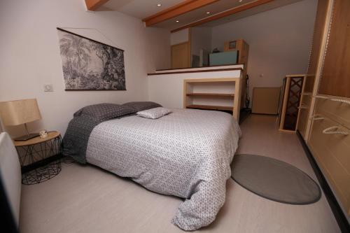 une petite chambre avec un lit et un miroir dans l'établissement La Maison du Pescadou Gruissan Village-Autentique-Plage, à Gruissan