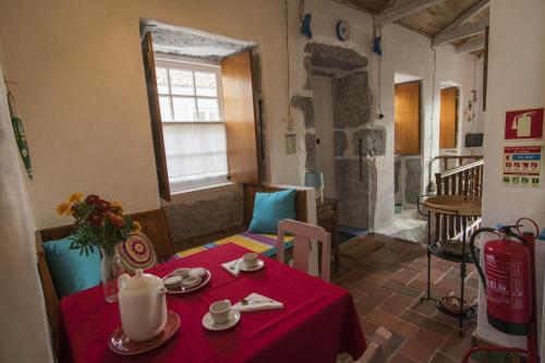 a table with a red table cloth in a room at Casa da Trigueirinha in Angra do Heroísmo