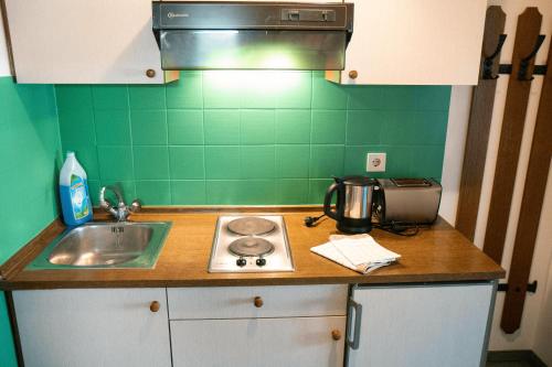 a kitchen counter with a sink and a stove at Appartementhaus Huber in Abersee 