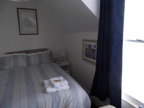 a bedroom with a bed with towels on it at The Beaumont in Sittingbourne