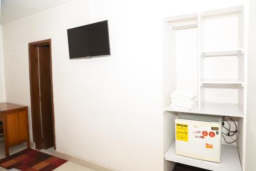 a room with a white wall with a tv on the wall at Ayenda 1131 Casa Valencia in Manizales