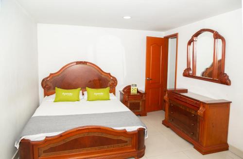 a bedroom with a bed and a dresser and a mirror at Ayenda 1131 Casa Valencia in Manizales