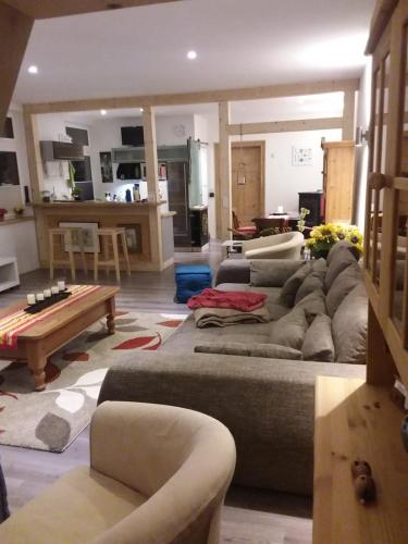 ein Wohnzimmer mit einem großen Sofa und einem Tisch in der Unterkunft Ferienwohnung Casa Corleone in Apolda