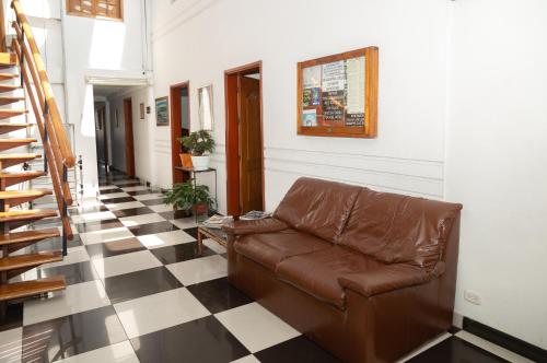 a leather couch in a hallway with a checkered floor at Ayenda 1131 Casa Valencia in Manizales