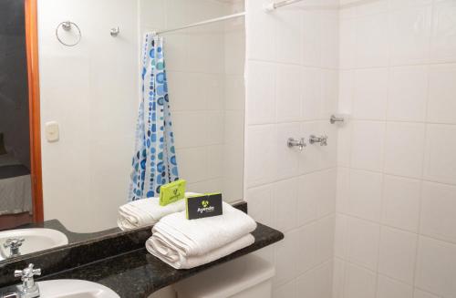 y baño con lavabo, ducha y toallas. en Ayenda 1131 Casa Valencia, en Manizales