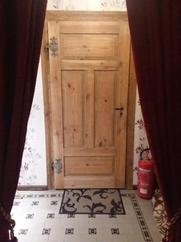 Cette chambre dispose de carrelage et d'une porte en bois. dans l'établissement Ferienwohnung Casa Corleone, à Apolda