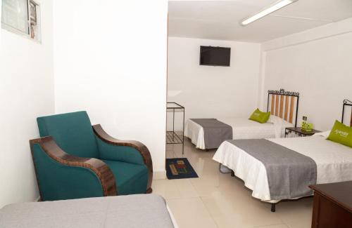 a hotel room with two beds and a blue chair at Ayenda 1131 Casa Valencia in Manizales