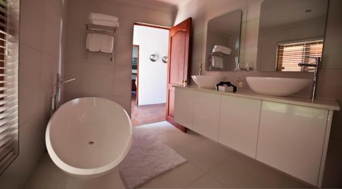 
a bathroom with a sink, toilet and bathtub at Aaldering Luxury Lodges in Stellenbosch
