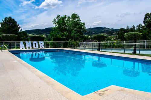 a large swimming pool with blue water at Quintinha dos Queiroses in Vila Boa de Quires