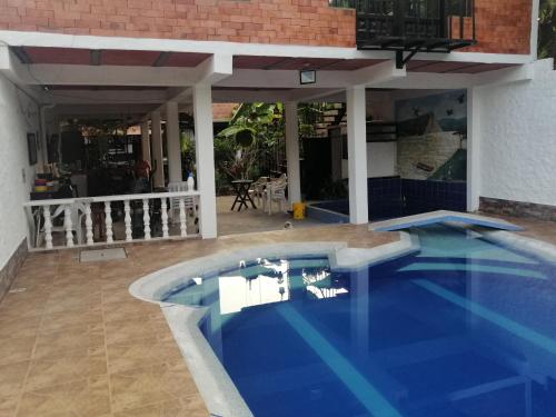 a swimming pool in front of a house at Brisas del Magdalena in La Dorada