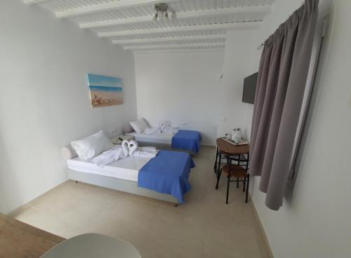 a room with two beds and a table with a desk at Maya Apartments in Dexamenes