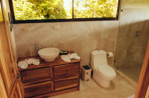 a bathroom with a sink and a toilet and a window at Drake Bay Greenleaf in Drake