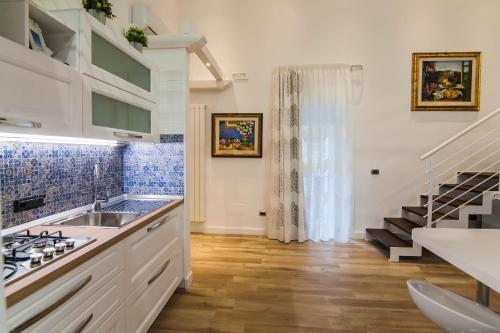 uma cozinha com um lavatório e uma escada em Solimena House 44 em Nocera Inferiore