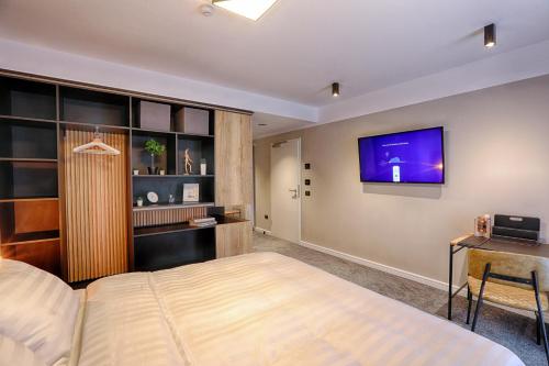 a bedroom with a bed and a tv on the wall at Nani Nani Boutique in Braşov