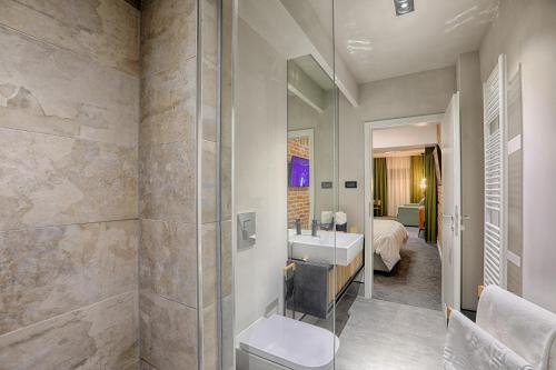 a bathroom with a toilet and a sink and a bed at Nani Nani Boutique in Braşov