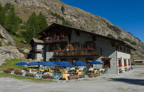 a building with chairs and umbrellas in front of it at Albergo Gran Paradiso in Valsavarenche
