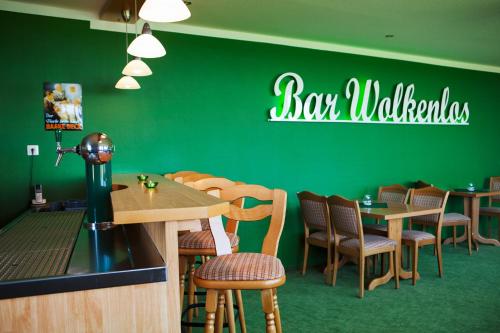 a restaurant with green walls and wooden tables and chairs at Hotel Hus Achtern Diek in Insel Neuwerk