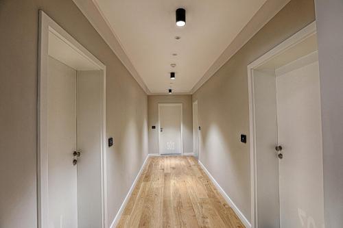a hallway with white walls and wooden floors and a ceiling at Nani Nani Boutique in Braşov