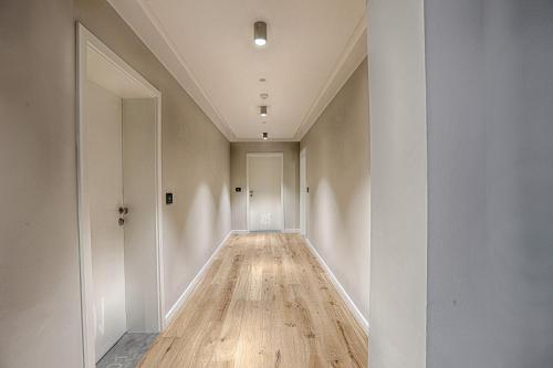 an empty hallway with white walls and wood floors at Nani Nani Boutique in Braşov
