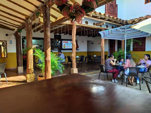 um grupo de pessoas sentadas em mesas em um restaurante em El Zaguan em Barichara