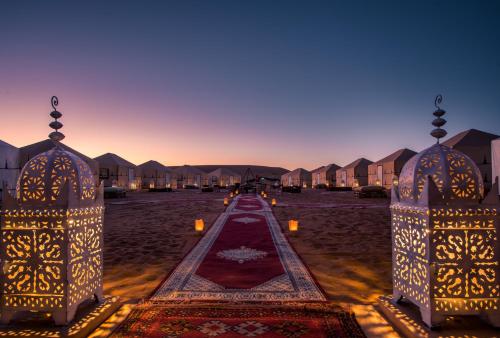 een uitzicht op een complex 's nachts met huizen bij Azawad Luxury Desert Camp in Merzouga