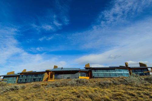 a building on top of a hill with a blue sky at Design Suites Calafate in El Calafate