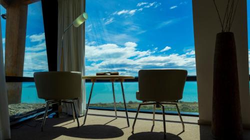 a table and two chairs in front of a window at Design Suites Calafate in El Calafate