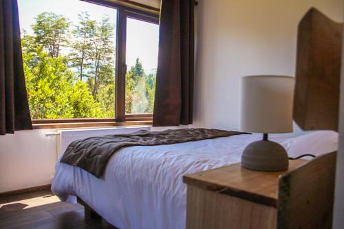 a bedroom with a bed and a large window at Entre Volcanes Lodge in La Ensenada