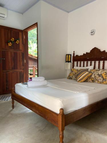 a bedroom with a large bed with white sheets at Casa da Polly IG in Abraão